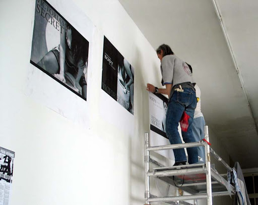 large prints are being installed at an art exhibit in Rotterdam. large prints are being installed at an art exhibit in Rotterdam.